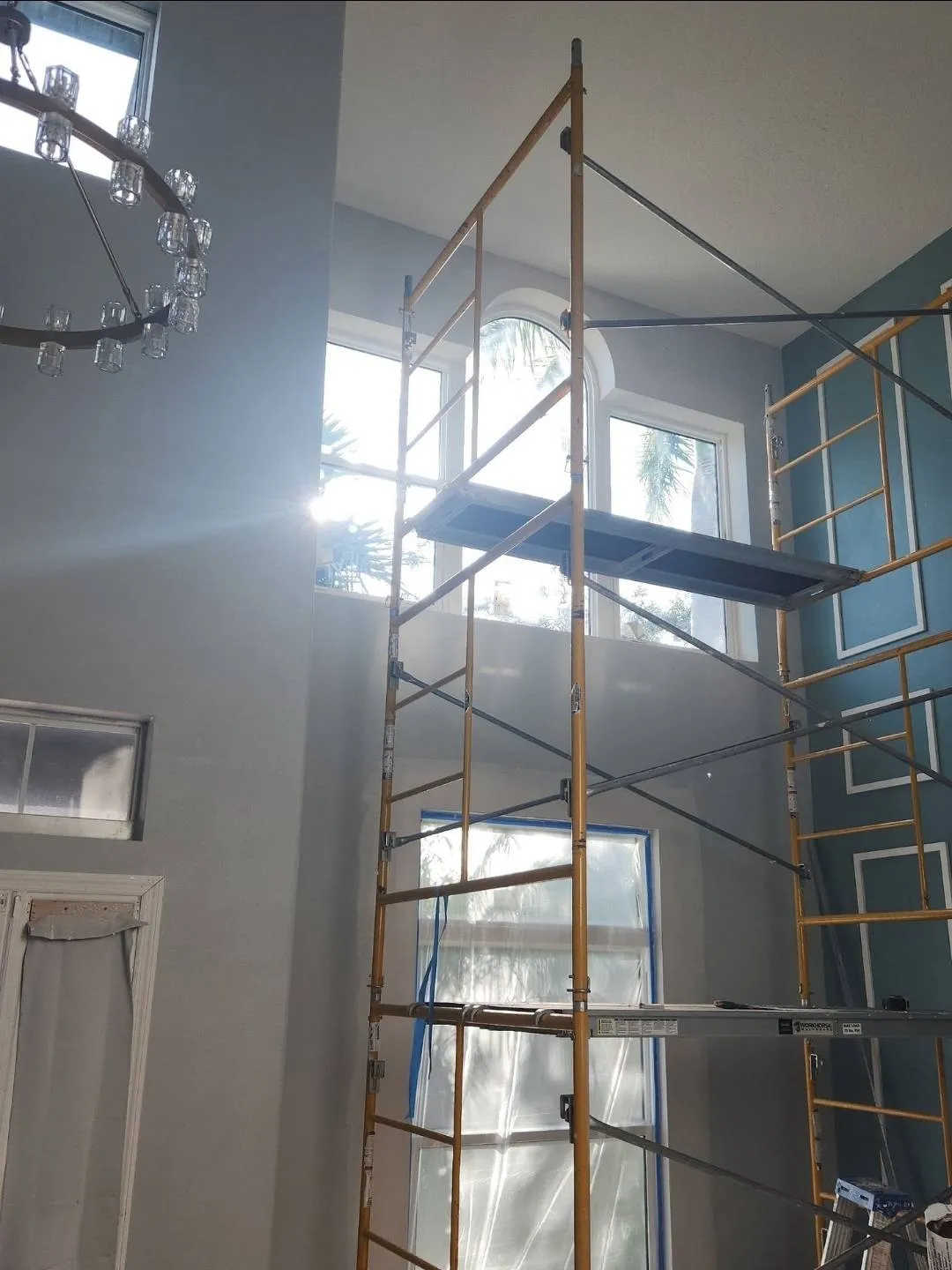 Crew scaffolding along a two-story home during exterior painting work