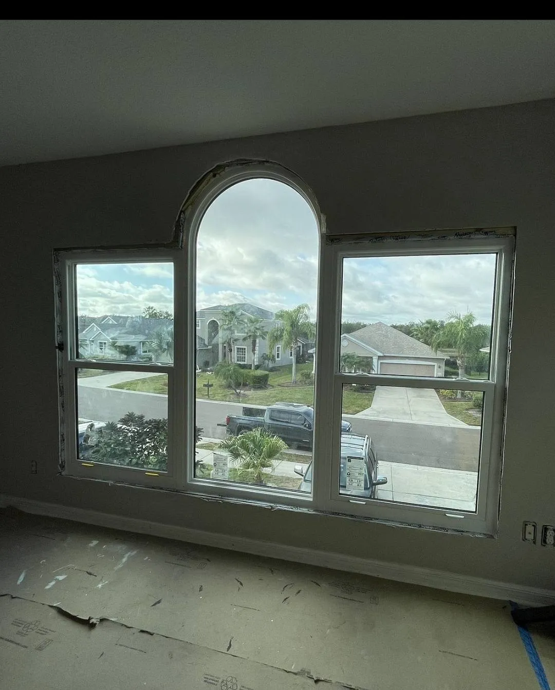Finished arched impact picture window framing a landscape view