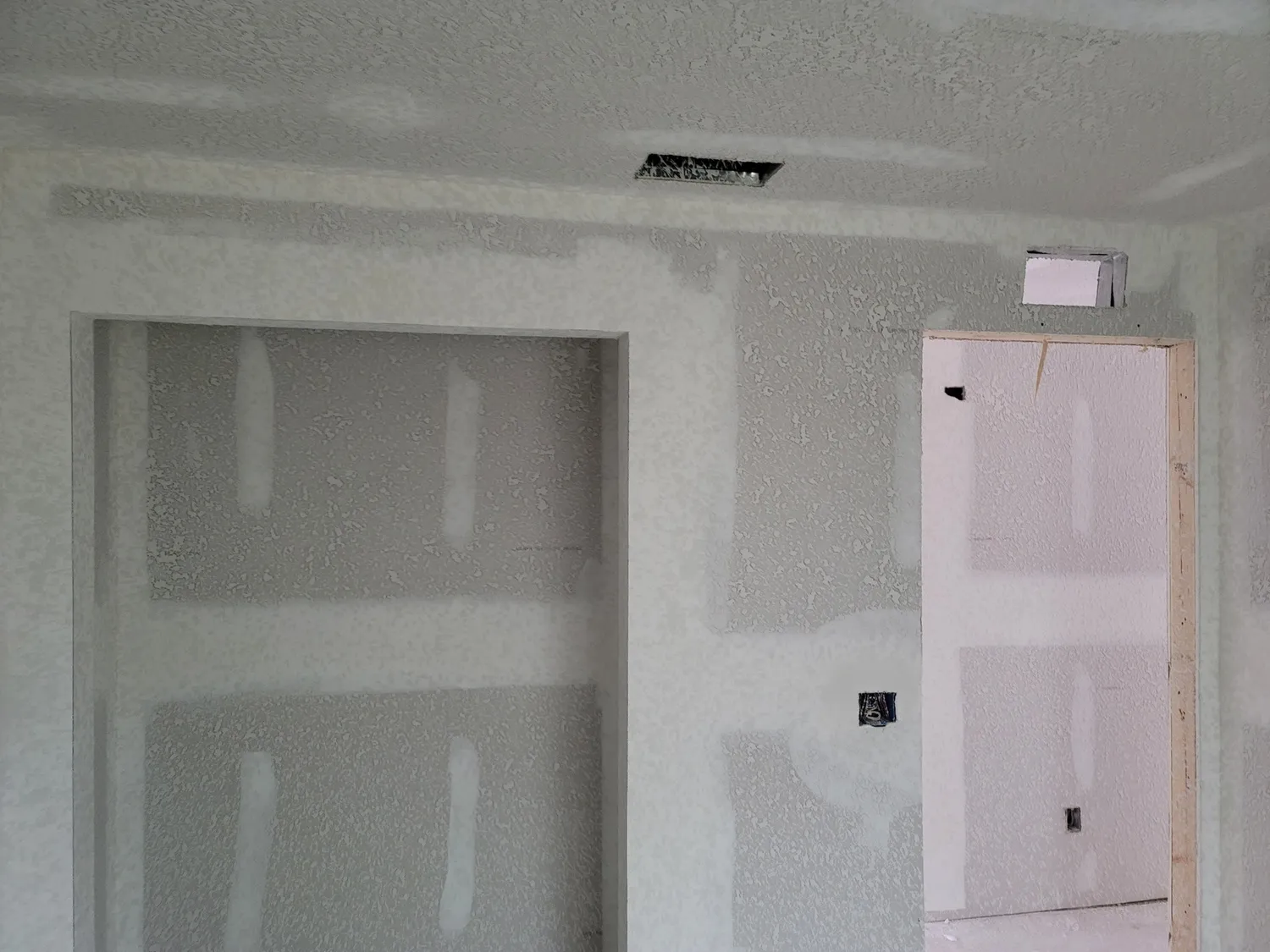 Room mid-renovation with drywall complete and trim work approaching