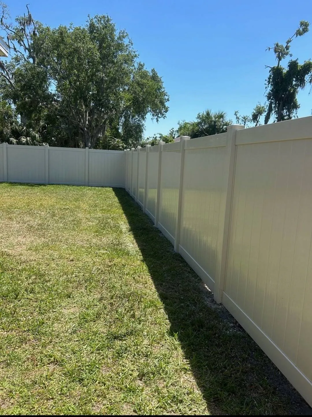 New tan vinyl privacy fence along a Manatee County backyard